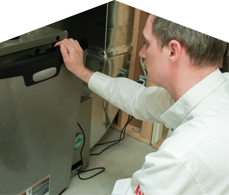 Peel HVAC professional installing a new furnace unit, aligning the front panel with surrounding ductwork and wiring in a residential utility space. Peel HVAC professional installing a new furnace unit, aligning the front panel with surrounding ductwork and wiring in a residential utility space.