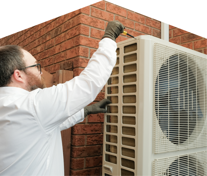 Peel HVAC specialist using a screwdriver to complete a heat pump installation beside a brick wall. Peel HVAC specialist using a screwdriver to complete a heat pump installation beside a brick wall.