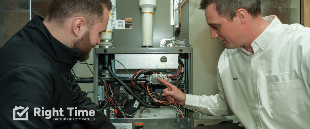 HVAC technician showing a homeowner the components of a high-efficiency gas furnace during an inspection.